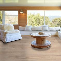 a living room filled with furniture and lots of window sill next to a white couch