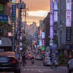 a city street filled with lots of traffic and people walking on the side of it