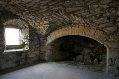 an empty room with stone walls and windows