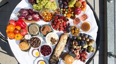 a table topped with lots of different types of fruits and vegetables on top of a white plate