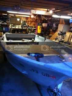 a boat is sitting in a garage with other tools