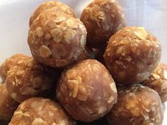 a white bowl filled with lots of oatmeal covered chocolate balls on top of a table