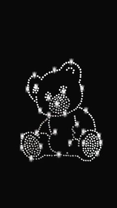 a teddy bear with stars on it's head and tail, sitting down in the dark