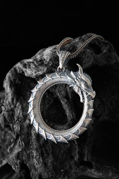 This Ouroboros dragon snake ring necklace is stylish and pretty ideal for everyday use. The engraving details of the 925k handmade silver pendant are very detailed and eye-catching. The jewelry is coated with oxide to emphasize the details of handmade engraving The best colors are Oxidized-Rose-Yellow and Rhodium Color on this product you can see all details clearly. You can find Product colors variations shown as representative on  image. Made from high-quality sterling silver, this ouroboros n Sterling Silver Engraved Snake Jewelry, Engraved Sterling Silver Snake Jewelry, Ouroboros Dragon, Unique Silver Jewelry With Dragon Design, Spiritual Sterling Silver Jewelry With Dragon Design, Unique Dragon Design Necklace For Collectors, Medieval Ouroboros, Ouroboros Necklace, Silver Jewelry With Dragon Design Round Pendant