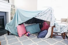 a living room with a fire place and couches covered by a blue tarp