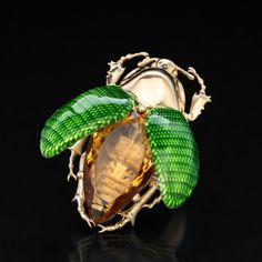 a ring with green leaves and an orange stone