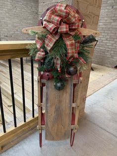 a wooden sled with christmas decorations on the front and back wheels, tied to it's sides