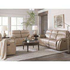 a man sitting on a recliner in a living room next to two couches