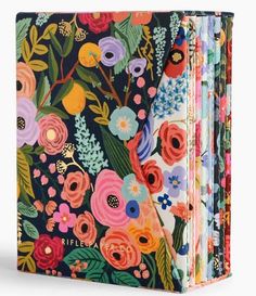 an open notebook with colorful flowers and leaves on the front, in multicolored colors