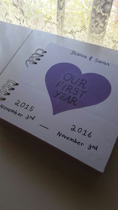 a wedding card with a heart on it sitting in front of a window sill