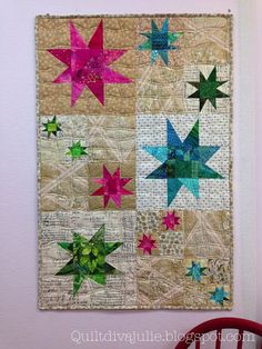 a quilted wall hanging with stars on it