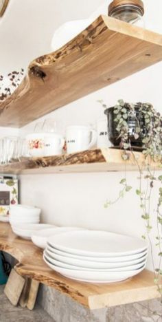 plates and bowls are stacked on wooden shelves