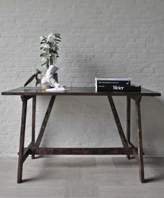 a wooden table with books and a plant on top