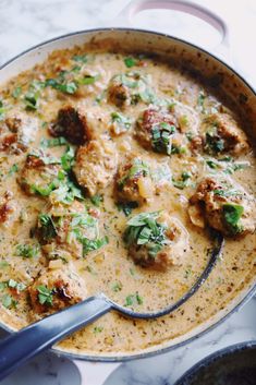 a skillet filled with meatballs and gravy on top of a table