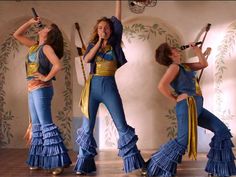 four women dressed in blue and gold dancing