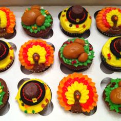 twelve cupcakes decorated like turkeys, turkey hats and other thanksgiving decorations are arranged in a box