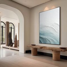 a large painting hanging on the wall in a living room next to two wooden benches