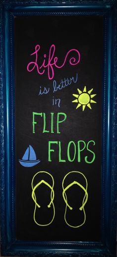 a chalkboard sign with flip flops written on it in front of a blue frame