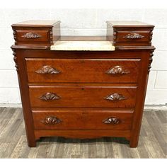 an antique chest of drawers with marble top and drawer pulls on the bottom, in walnut