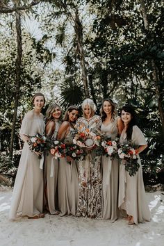 a group of women standing next to each other in front of trees and snow covered ground