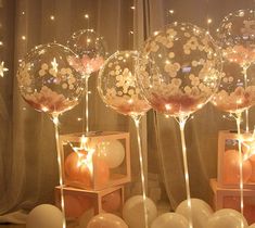 some balloons that are sitting in front of a window with lights on them and stars