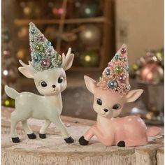 two little deer figurines sitting next to each other on top of a table