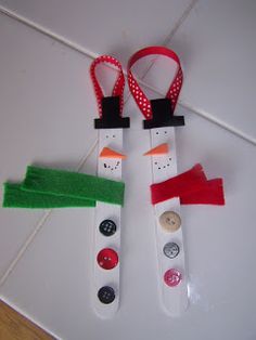 two snowmen made out of plastic and some buttons on a string attached to the wall