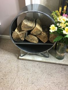 a bunch of logs sitting on top of a table next to a vase with flowers