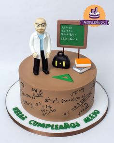 a cake with a man standing on top of it next to a chalkboard and books