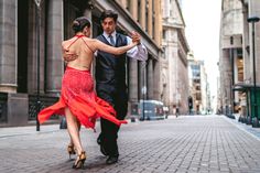 a man and woman are walking down the street with their arms wrapped around each other