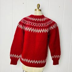 "A warm, chunky-knit pullover style sweater with a lovely geometric pattern around the yoke. A simpler version of the pattern repeats on the sleeves and hem. This sweater was worked bottom-up in the round to the underarm, the sleeves were worked separately, and then all parts were joined together on one needle to the yoke and neck opening. Likely a Mens Large, but please see details below. The measurements are taken while the sweater is laying flat. Measures:  20\" (50 cm) across shoulders (roughly, as the shoulders slope)  23\" (57.5 cm) across chest 29\" (72.5 cm) from front neck to hem 22\" (55 cm) from underarm to end of sleeve 40\" (100 cm) around at bottom hem" Cozy Fair Isle Pattern Sweater, Red Nordic Knitted Sweater, Red Nordic Style Knitted Sweater, Nordic Chunky Knit Sweater For Fall, Fall Knitting Pattern With Fair Isle Design, Fall Fair Isle Knitting Pattern, Vintage Winter Knitted Patterns, Vintage Knitted Patterns For Winter, Fall Nordic Style Knitting Pattern