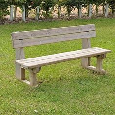 a wooden bench sitting on top of a lush green field