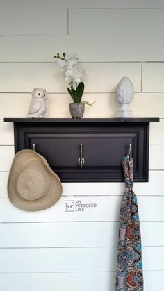 a hat and tie are hanging on the wall next to a coat rack with an owl figurine