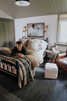 a man laying on top of a bed in a bedroom