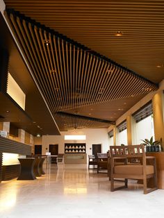 an empty lobby with wooden benches and tables