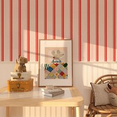 a teddy bear sitting on a chair next to a table with a painting and some books