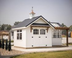 a small white building with a black roof