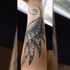 the arm is decorated with black and white tattoos