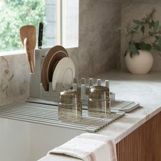 Looking to maximize your kitchen space? Try our Over the Sink Dish Pad + Rack Bundle. The minimal, roll-out drying mat is easy to store away when not in use. With an instant drying Diomat(R) stone that anchors one end and silicone-covered stainless iron rods that roll out over your sink, it can hold even the heaviest pans – while protecting all of your dishes. Pair with our adaptable Dish Rack that sits on the stone to keep your counters dry and clear. Includes 1 Over the Sink Dish Pad + 1 Dish Dish Rack In Sink, Drying Rack Kitchen Ideas, Aesthetic Kitchen Sink Area, Over The Sink Drying Rack, Aesthetic Dish Drying Rack, Dish Drying Rack Space Saving, Dish Rack Ideas, Dishes Drying Rack, Aesthetic Sink