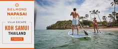 two people stand on surfboards in the ocean with palm trees and blue sky behind them