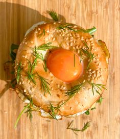 an overhead view of a bagel with sesame seeds, tomato and sprouts