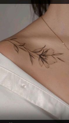 the back of a woman's neck with leaves on it