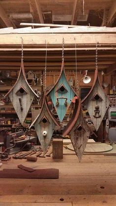 several wooden boats hanging from hooks in a workshop