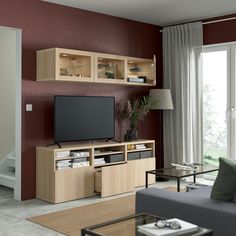 a living room with red walls, white furniture and a flat screen tv on the wall