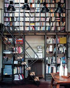 a living room filled with lots of books and furniture