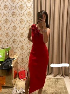 a woman in a red dress taking a selfie