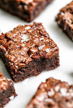 chocolate brownies with coconut flakes are arranged on a white tablecloth, ready to be eaten