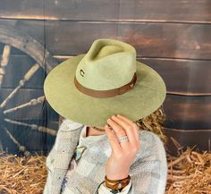 The Highway western hat is the perfect touch of cowgirl in a simple style. A bow tie ribbon hatband adorns the pinch front crease crown. The iconic "C" is hand-branded on the front of the crown. This sleek cowgirl hat is versatile enough to wear on a night out on the town, or dressed down with old blue jeans. You can't go wrong with this Charlie 1 Horse best-seller. Made in Mexico Pinchfront crown 3 3/4” brim Bow tie ribbon hatband Wool felt Branded “C” on the crown Olive in Color Country Style Fedora For Kentucky Derby With Flat Crown, Western Style Fedora With Flat Crown For Country Events, Country Style Fedora With Flat Crown For Country Events, Flat Crown Fedora For Kentucky Derby And Western Events, Country Style Fedora For Western-themed Events, Flat Crown Fedora For Kentucky Derby, Western Fedora With Flat Crown, Fedora For Country Events With Flat Crown, Adjustable Hat Bands For Country Events In Fall