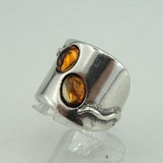 Great New sterling silver band. A very beautiful ring made of polished 925 sterling silver with two 7mm X 5mm oval Amber stones. Enjoy it forever! Front width: 18mm / 0.708 in. Back width: 6mm / 0.236 in. Stamped 925. This beauty will be sent to you in a gift package. (All stains, if are any, are due to camera). Please feel free to contact us at any matter. Material: Sterling Silver 925 925 Thank you for looking. Please see my other items in this shop: http://www.etsy.com/shop/hadarjewelry To se Modern Amber Rings For Anniversary, Modern Amber Jewelry For Anniversary, Modern Amber Jewelry With Citrine, Modern Amber Citrine Jewelry, Amber Open Ring For Anniversary, Baltic Amber Ring For Anniversary, Unique Citrine Ring With Polished Finish, Unique Citrine Rings With Polished Finish, Handmade Modern Amber Rings