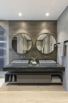 a bathroom with two sinks and mirrors on the wall